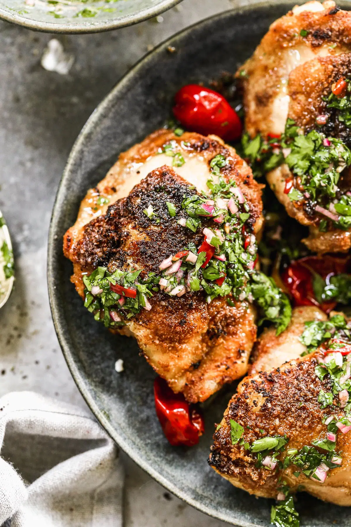 Air Fryer Chicken Thighs are a true winner in the realm of delicious, easy chicken dinners. We dust bone-in, skin-on chicken thighs with garlic, onion, and cumin then cook them inn the air fryer until the skin is irresistibly crispy and the inside is tender and moist. We drizzle it all with a fiiery chimichurri and dig in! 