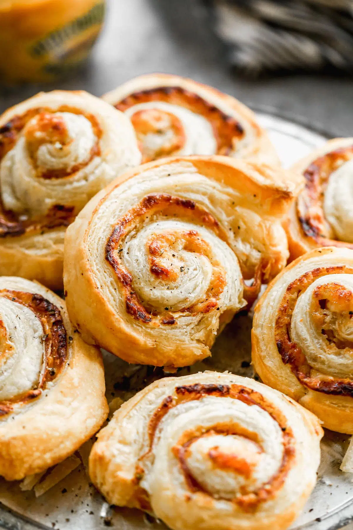 Puff Pastry Pinwheels made with store-bought puff pastry sheets, sweet and hot mustard, nutty parmigiano reggiano and  salty paper-thin slices of prosciutto. Sure to be the hit of your party!