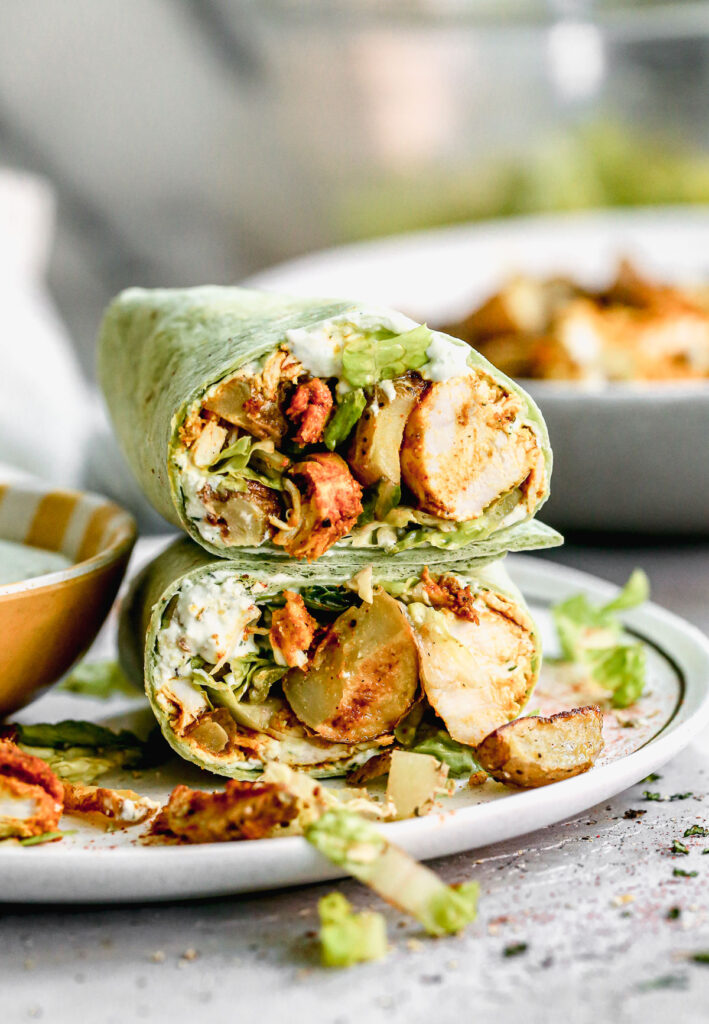 Chicken Shawarma Wraps are filled with tender, flavorful chicken and crispy potatoes then smothered in garlicky Greek yogurt sauce, lettuce and tomatoes.