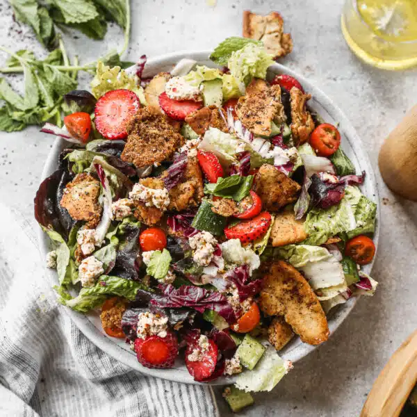 A trio of crisp lettuces, fresh veggies, sweet strawberries, tangy goat cheese and crunchy sumac-infused naan chips are the makings of our version of a Fattoush Salad Recipe. This Mediterranean-inspired salad is a bright summery salad you’ll want to eat all season long.