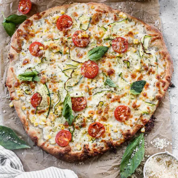 Cottage Cheese Pizza is the summer pie you never knew you needed. With a creamy, tangy cottage cheese and sharp provolone base and a delicate shaved zucchini, sweet corn and cherry tomato topping, this veggie forward pizza is truly a winner.