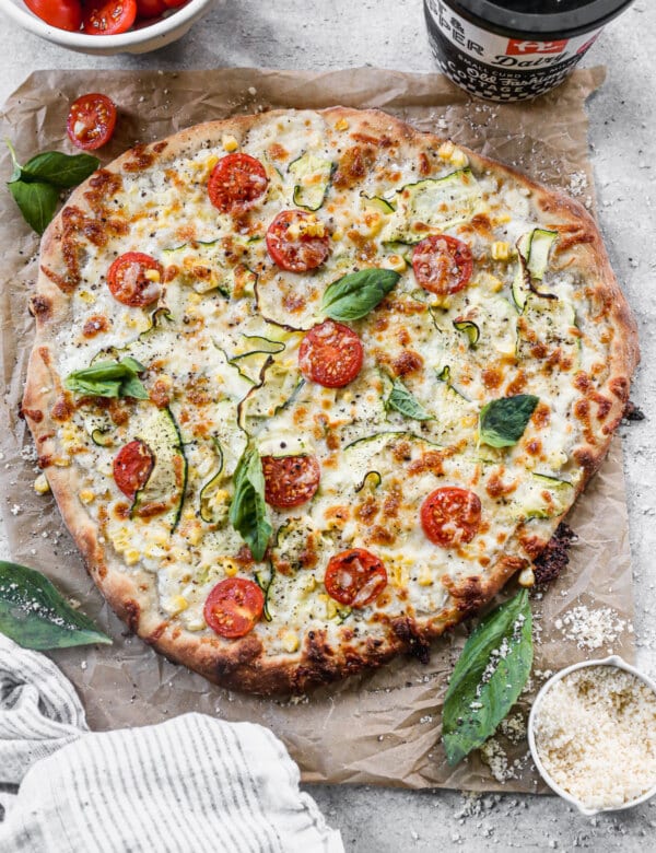 Cottage Cheese Pizza is the summer pie you never knew you needed. With a creamy, tangy cottage cheese and sharp provolone base and a delicate shaved zucchini, sweet corn and cherry tomato topping, this veggie forward pizza is truly a winner.
