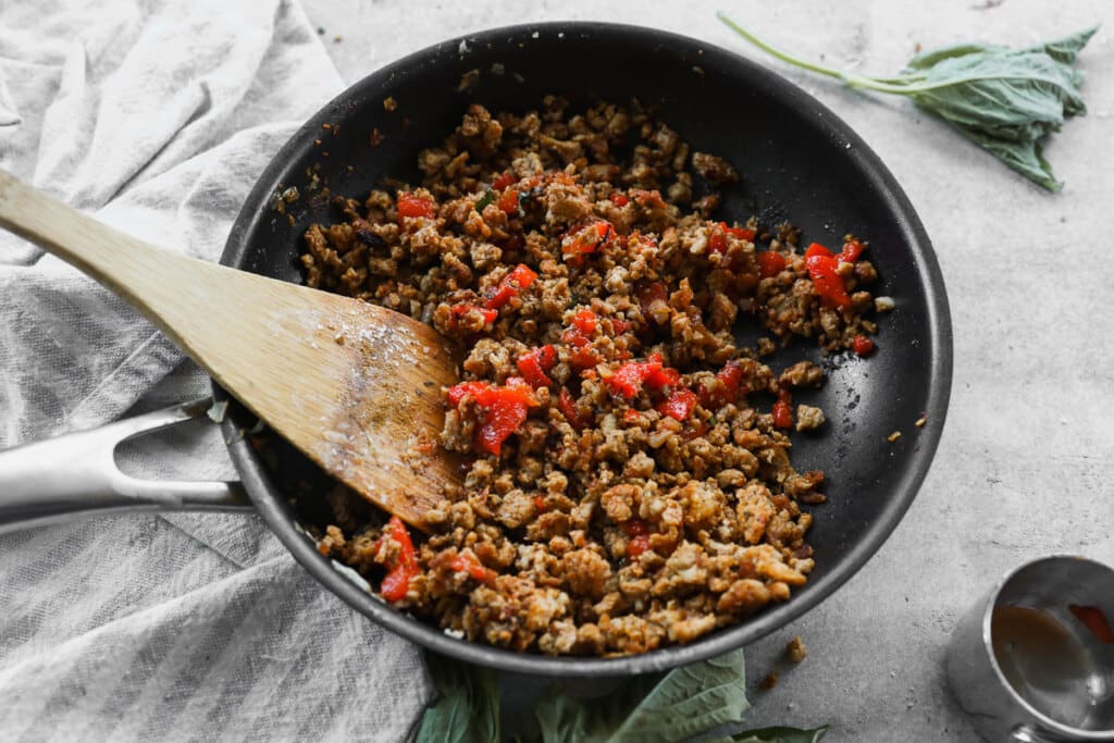 Ground chicken in skillet with roasted red peppers