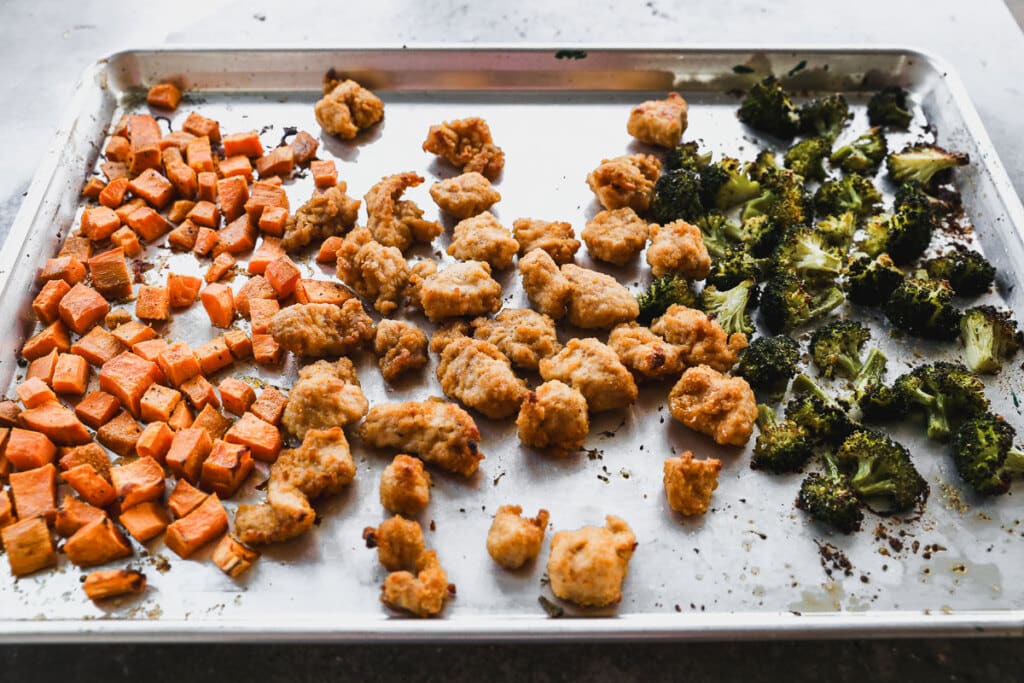 Roasted sweet potatoes, broccoli and chicken nuggets on a sheet pan
