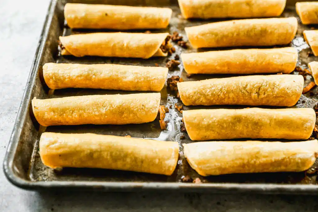 beef taquitos on baking sheet before going in the oven