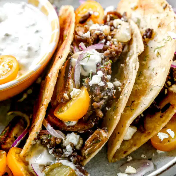 Our lamb tacos are stuffed with gyro-flavored lamb, tangy feta cheese and crisped to perfection in a hot cast-iron skillet. After the tortilla becomes ultra crispy and the feta melts into a tangy oblivion, we open them up and stuff each taco with store-bought tzatziki (another shortcut), juicy cherry tomatoes, paper-thin red onions, and plenty of fresh dill.
